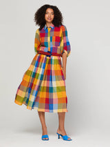Woman wearing a colorful checkered skirt on a plain background