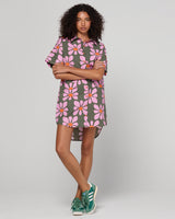 Woman wearing a floral dress with a plain background