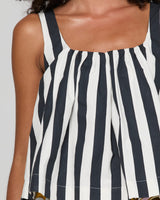 Close-up of a model wearing a sleeveless top with vertical navy and white stripes, featuring a square neckline and wide straps.
