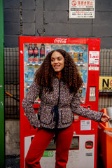 Fashion Model standing next to a Coca-Cola vending machine in an urban Japan setting. Wearing Boom Shankar Riko print jacket. 